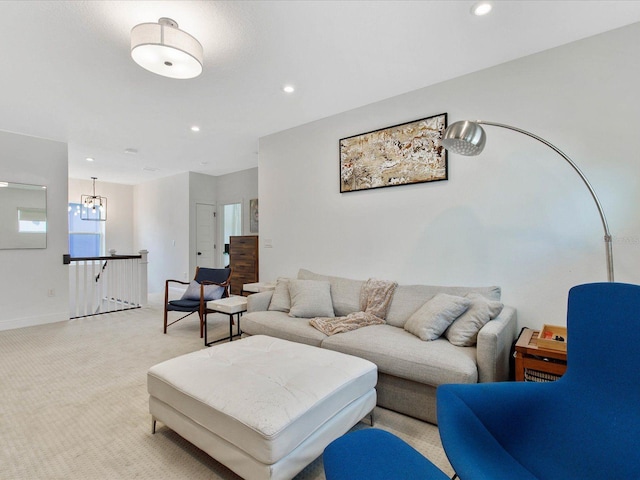 carpeted living room featuring a notable chandelier