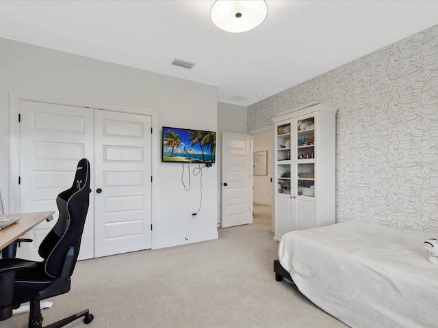 bedroom featuring light carpet and a closet