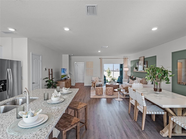 dining area featuring a textured ceiling, dark hardwood / wood-style flooring, and sink