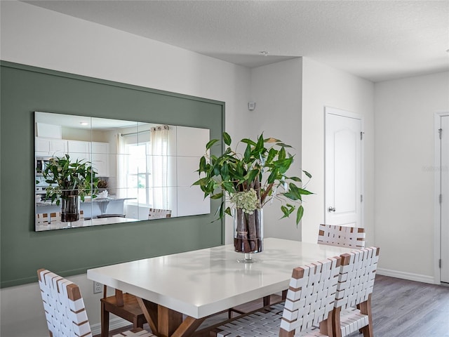 dining room featuring a textured ceiling and light wood-type flooring