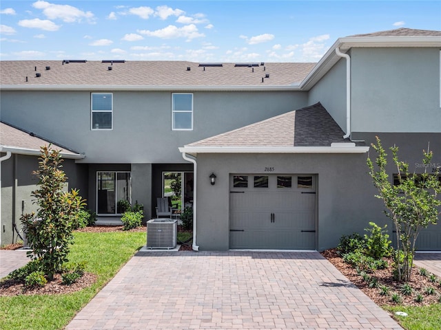 view of front of home featuring a garage and cooling unit