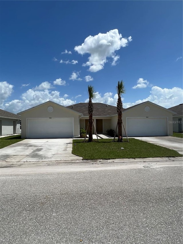 single story home with a garage and a front yard