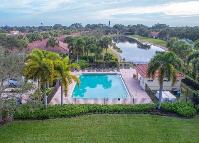 view of pool with a patio area, a water view, and a yard