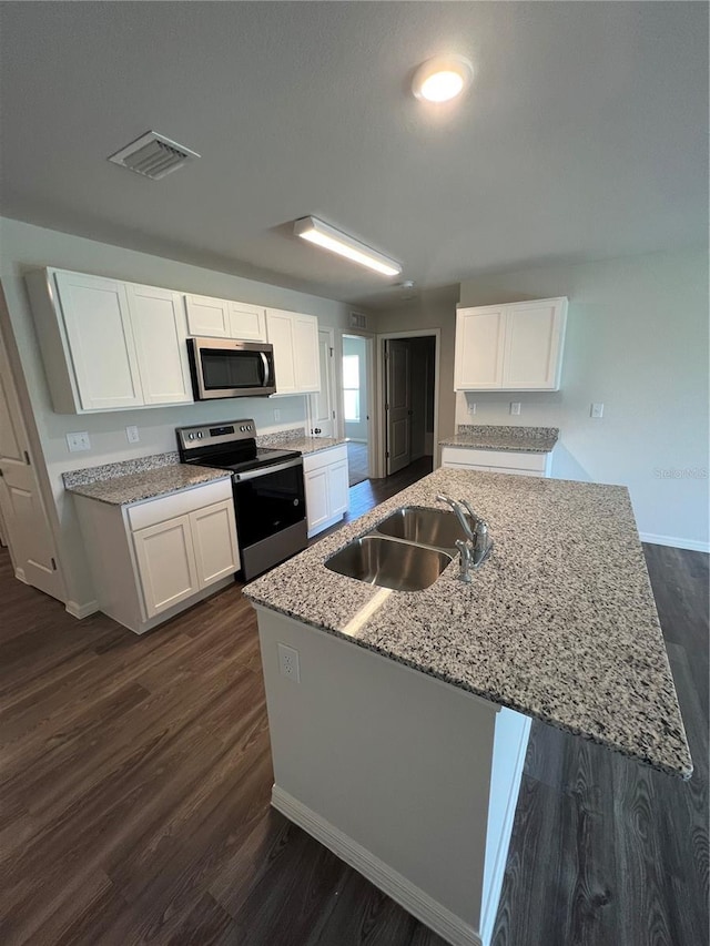 kitchen with appliances with stainless steel finishes, dark hardwood / wood-style flooring, light stone counters, sink, and white cabinetry