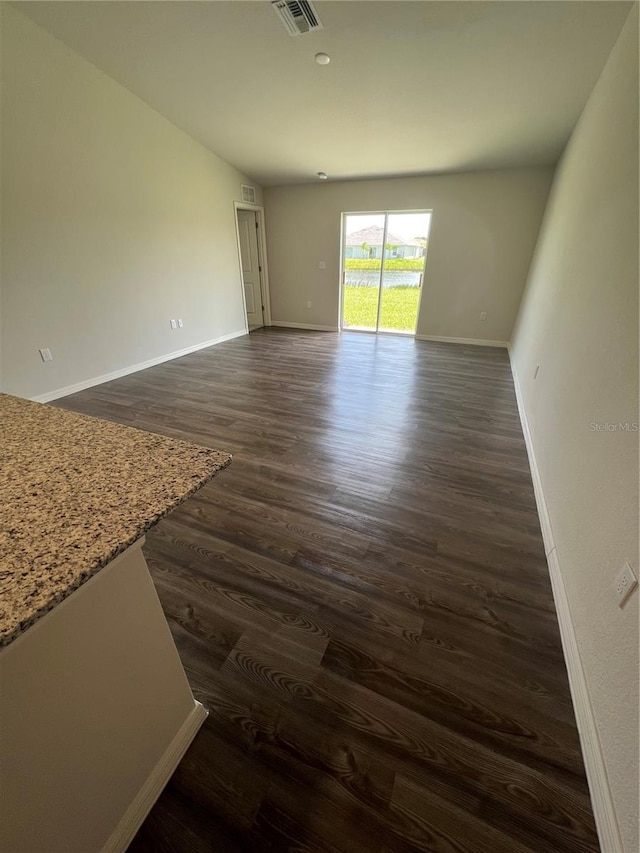 unfurnished room with dark wood-type flooring