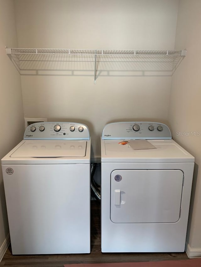 washroom with dark wood-type flooring and washing machine and clothes dryer