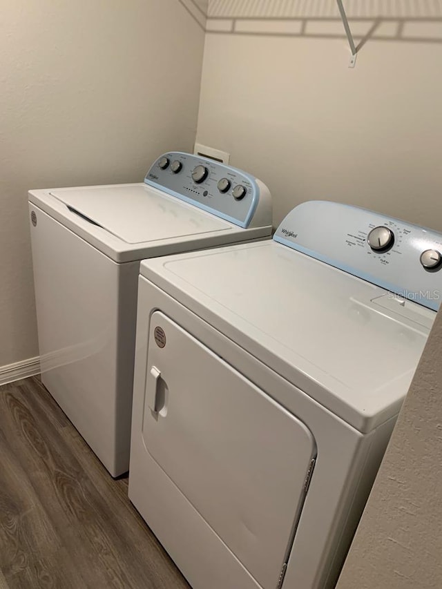 clothes washing area with hardwood / wood-style floors and independent washer and dryer