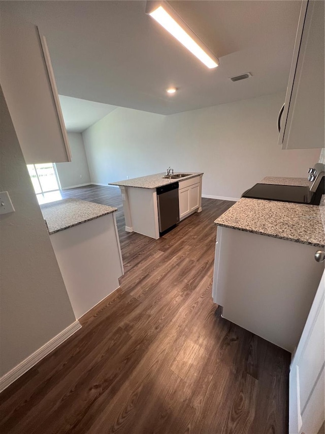 kitchen with white cabinets, light stone counters, dishwasher, range, and an island with sink