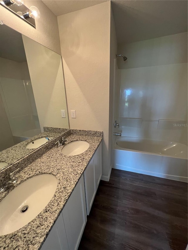 bathroom with hardwood / wood-style floors, vanity, and  shower combination