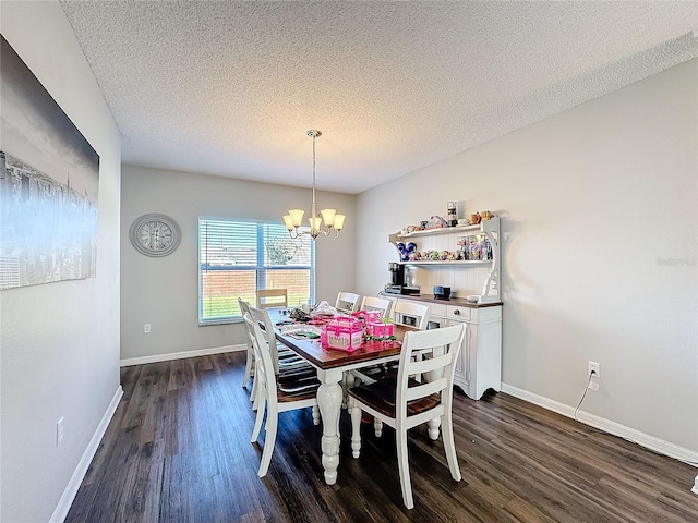 dining area featuring a textured ceiling, dark hardwood / wood-style flooring, and an inviting chandelier