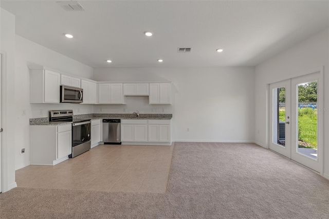 kitchen with french doors, white cabinets, light colored carpet, and appliances with stainless steel finishes