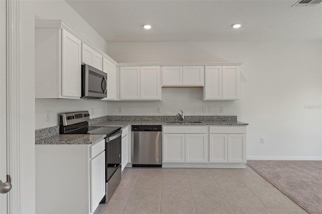 kitchen featuring light tile patterned floors, white cabinetry, sink, and appliances with stainless steel finishes