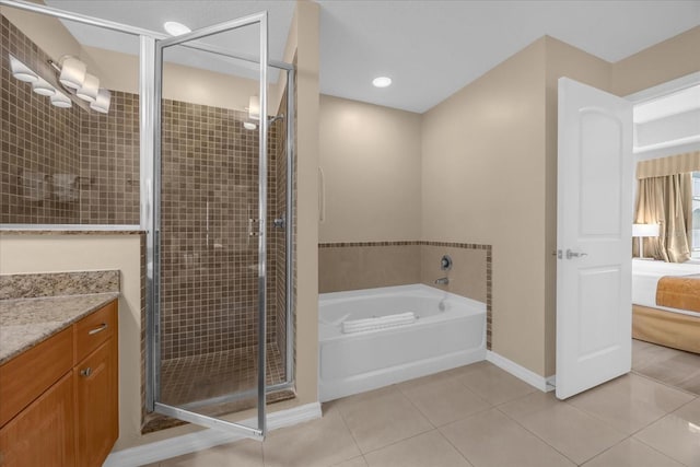 bathroom with tile patterned flooring, vanity, and shower with separate bathtub