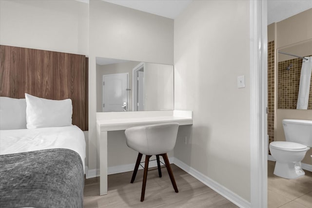 bedroom featuring built in desk and light hardwood / wood-style floors