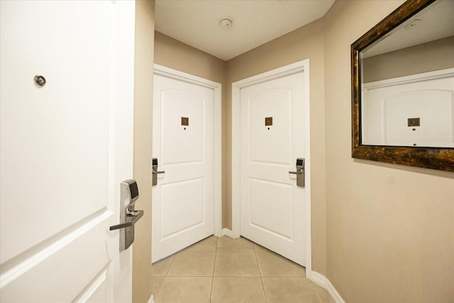 entryway with baseboards and light tile patterned floors