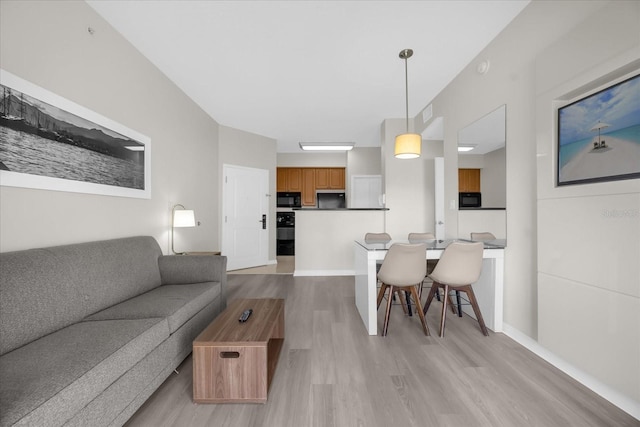 living area with light wood-style floors and visible vents