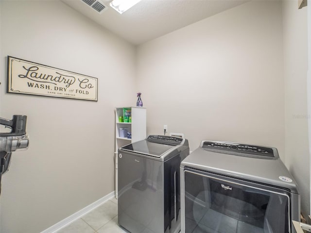 washroom featuring light tile patterned floors and washing machine and dryer