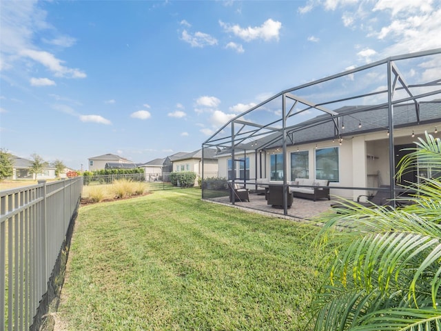 view of yard featuring a patio, outdoor lounge area, and glass enclosure