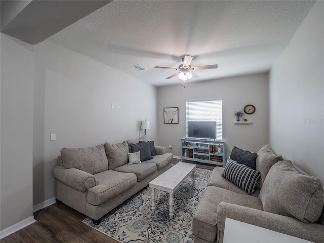 living room with ceiling fan, dark hardwood / wood-style floors, and a textured ceiling