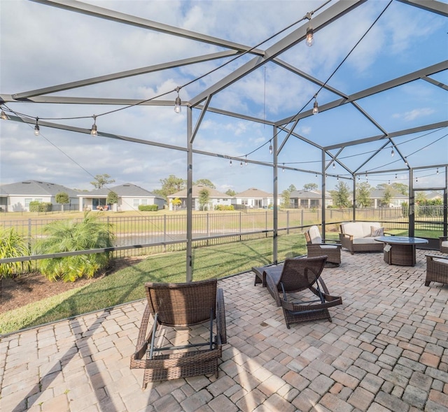 view of patio / terrace featuring an outdoor living space with a fire pit and glass enclosure