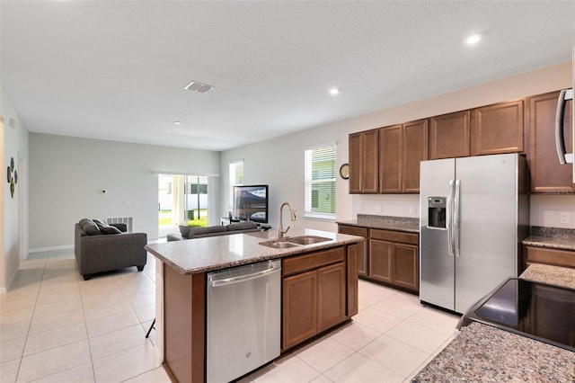 kitchen featuring appliances with stainless steel finishes, a center island with sink, light tile patterned flooring, and sink