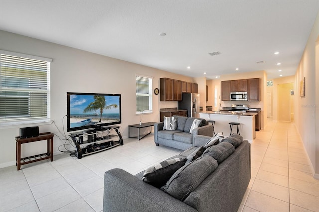 tiled living room with sink and plenty of natural light