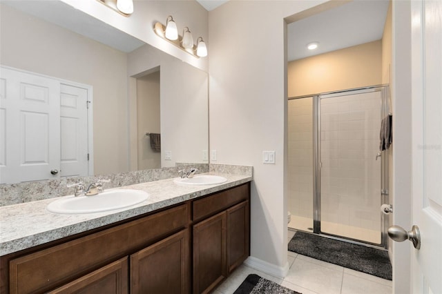 bathroom with a shower with door, tile patterned floors, and vanity