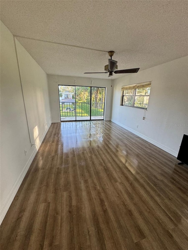 empty room featuring a textured ceiling, dark hardwood / wood-style floors, and ceiling fan