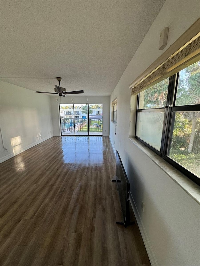 empty room featuring ceiling fan, dark hardwood / wood-style flooring, and a textured ceiling