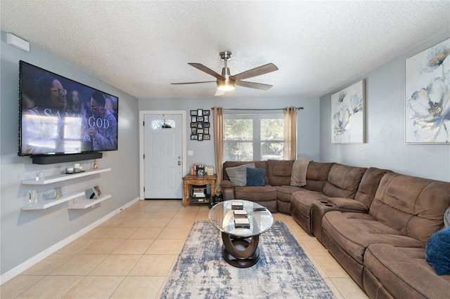 living room featuring ceiling fan, light tile patterned floors, and a textured ceiling