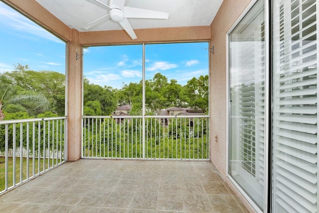 unfurnished sunroom featuring ceiling fan