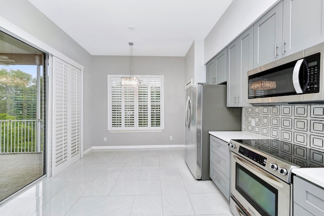 kitchen with stainless steel appliances, hanging light fixtures, gray cabinets, and a chandelier