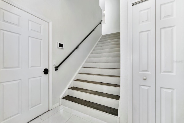 stairway with tile patterned floors