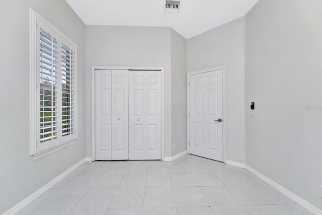 unfurnished bedroom with light tile patterned flooring and a closet