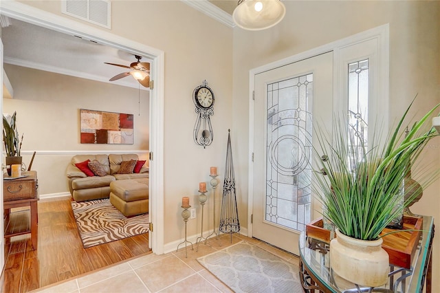 entrance foyer featuring crown molding, tile patterned flooring, and ceiling fan