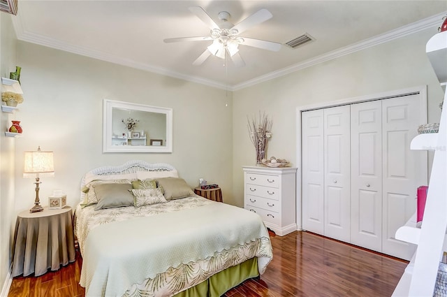 bedroom with crown molding, ceiling fan, a closet, and dark wood-type flooring