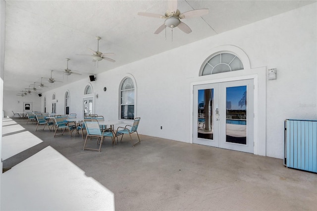 view of patio with ceiling fan, french doors, and radiator heating unit