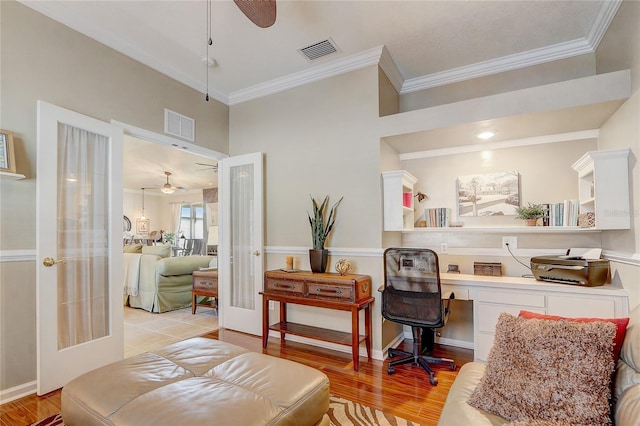 sitting room featuring french doors, ornamental molding, ceiling fan, built in desk, and light hardwood / wood-style floors