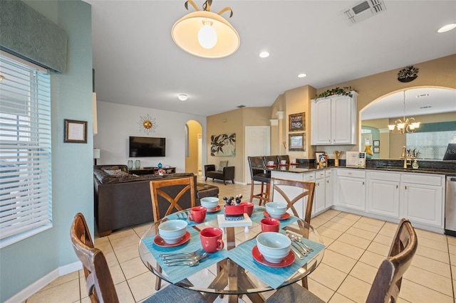 dining room with sink, plenty of natural light, light tile patterned floors, and a notable chandelier