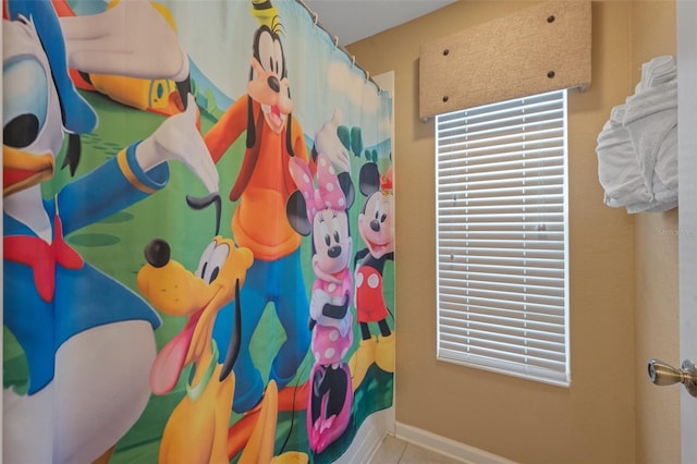 bathroom featuring curtained shower and tile patterned flooring