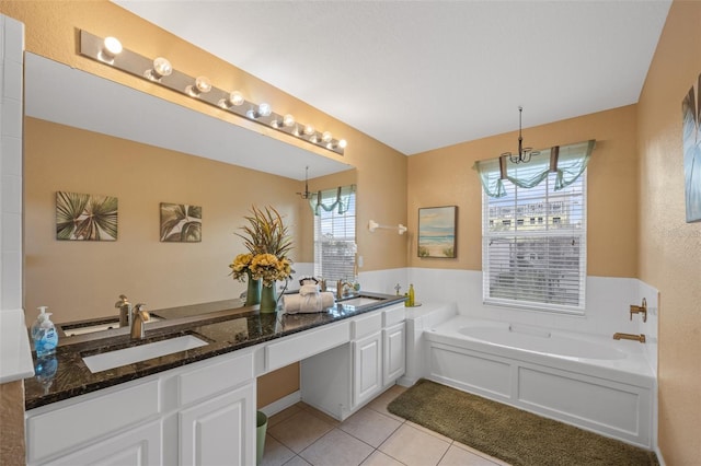 bathroom with tile patterned floors, a washtub, and vanity