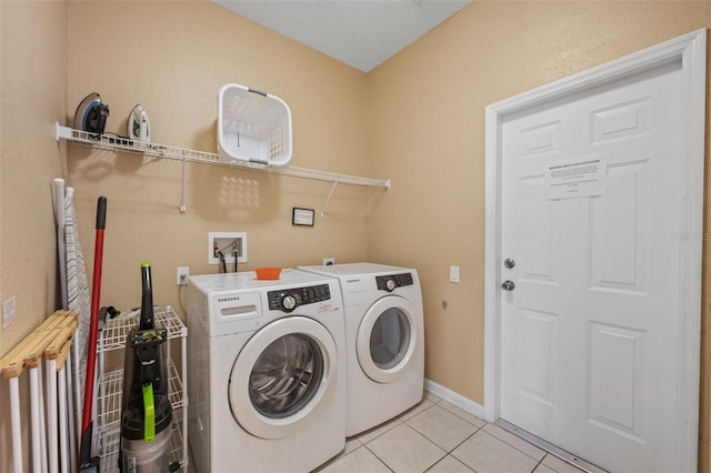 laundry room with independent washer and dryer and light tile patterned floors