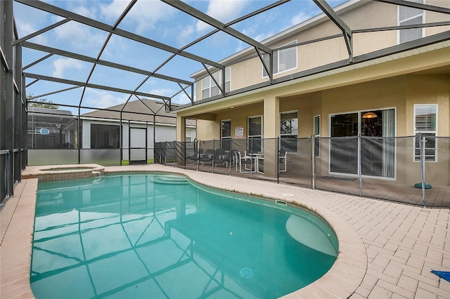 view of swimming pool featuring an in ground hot tub, glass enclosure, and a patio area