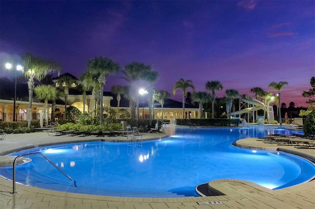 pool at dusk featuring a patio area