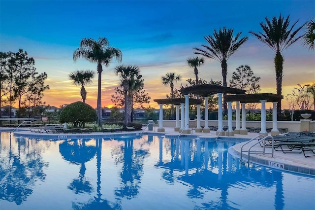 pool at dusk featuring a patio area