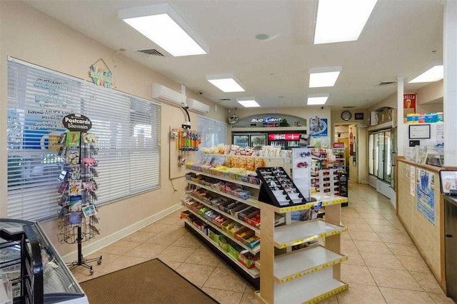 interior space with a wall mounted AC and light tile patterned floors