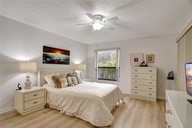 bedroom with a textured ceiling, light hardwood / wood-style floors, and ceiling fan