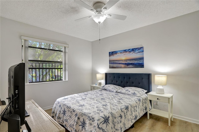 bedroom with hardwood / wood-style flooring, ceiling fan, and a textured ceiling