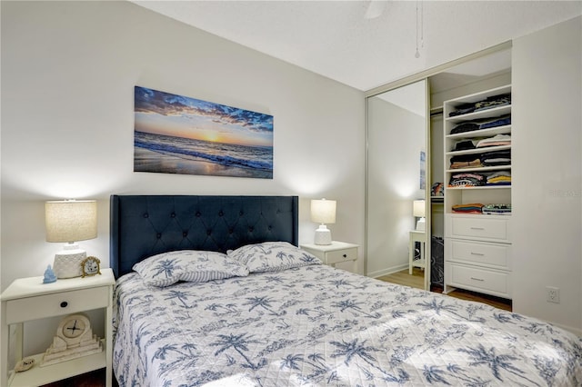 bedroom with dark hardwood / wood-style floors, a closet, and ceiling fan