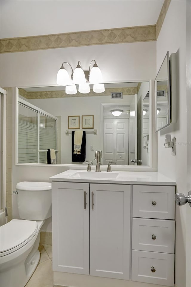 bathroom with tile patterned floors, vanity, toilet, and a shower with shower door